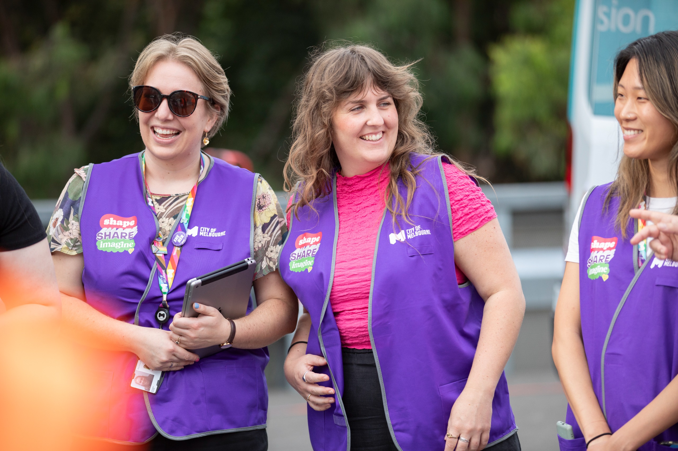 People holding clipboards in vests