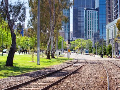 Tram tracks next to a park. 